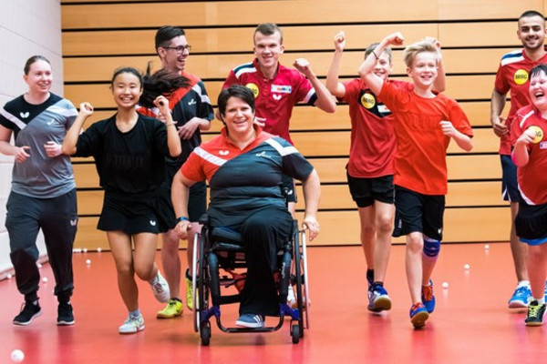 Inklusiver Sport, Übungsleiterin im Rollstuhl als Symbolbild für soziale Verantwortung