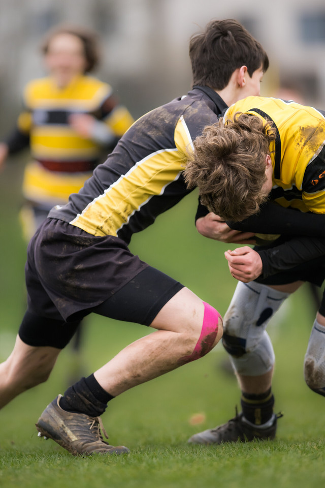 zwei Personen raufen sich im Rugby-Spiel