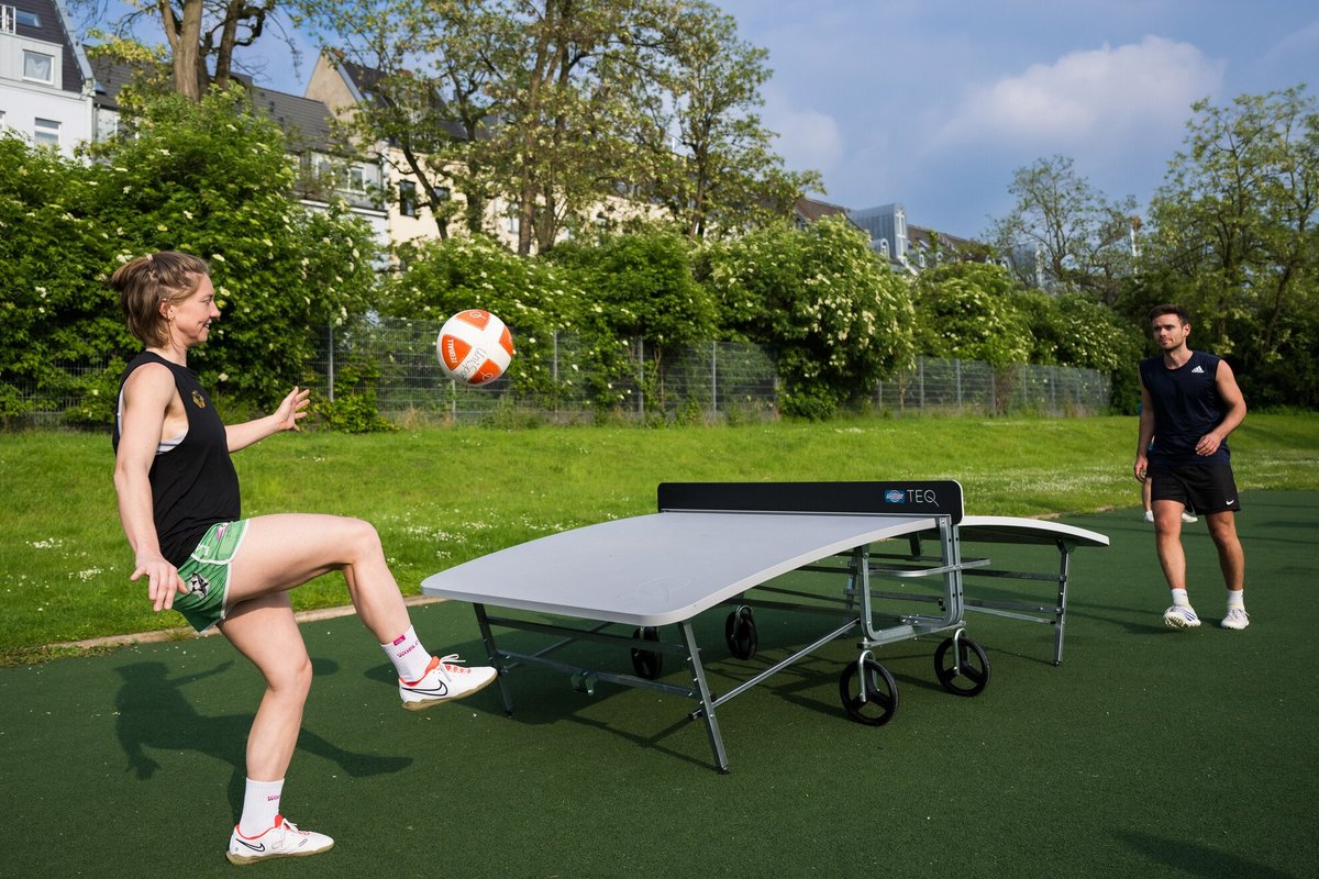 Frau und Mann spielen zusammen Teqball